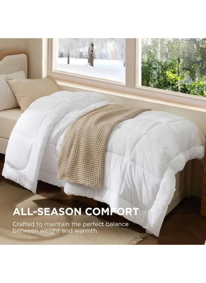 White duvet on a bed with a beige blanket on top of it