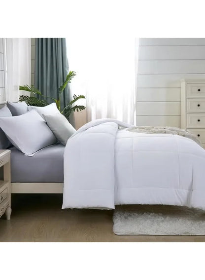 Bedroom with a bed featuring white bedding and white pillows, with a nightstand and plant in the background.